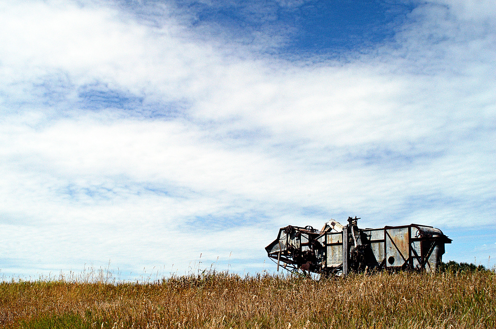 Open prairie and historic farm machinery photographed in Brandon, Manitoba